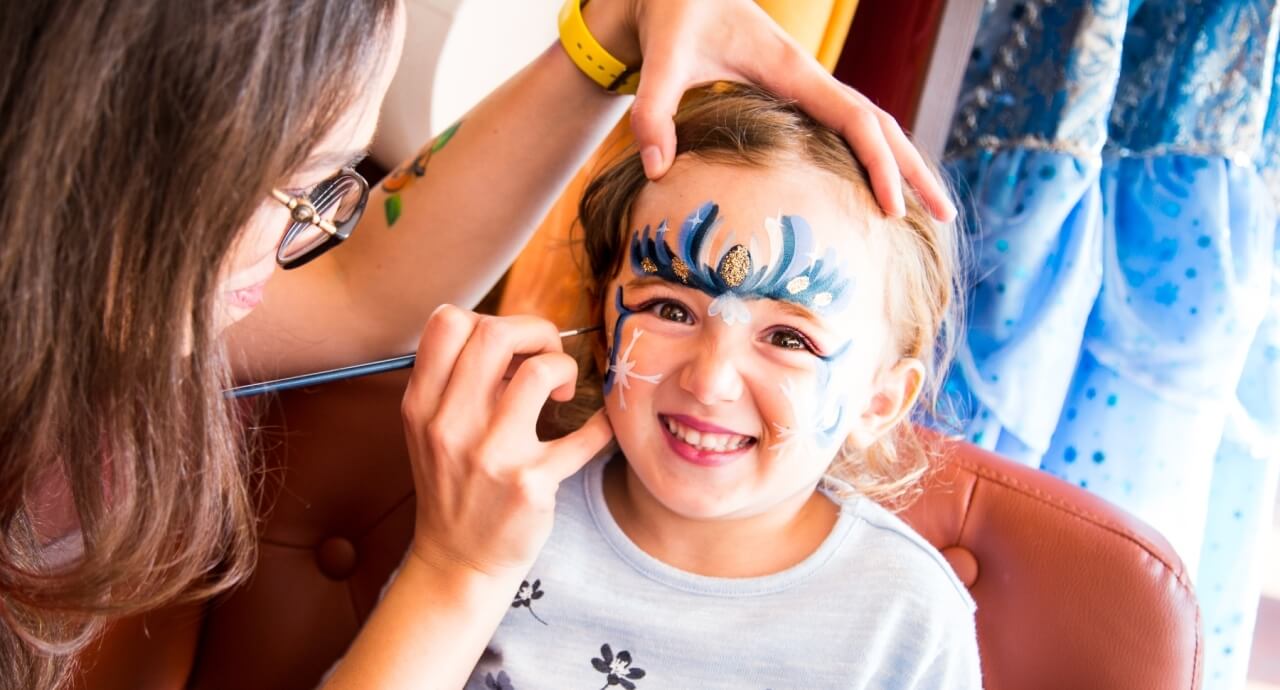 ragazza che trucca bambino per carnevale